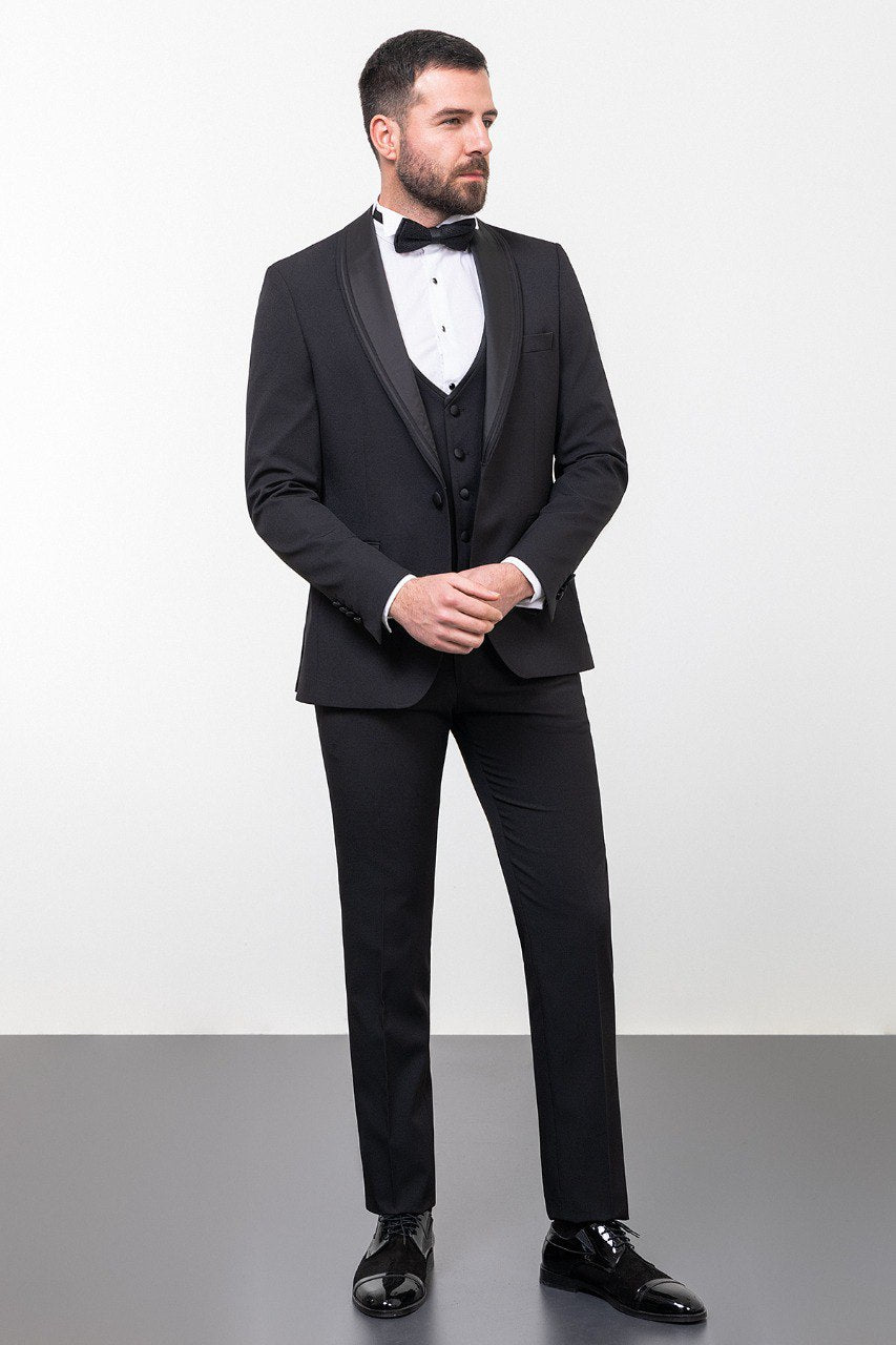 Man wearing a black 3-piece suit with a bow tie.