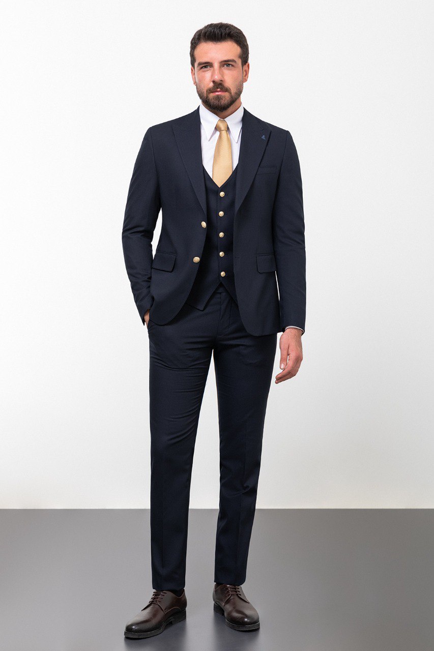 Man wearing a navy blue 3-piece suit with a gold tie.