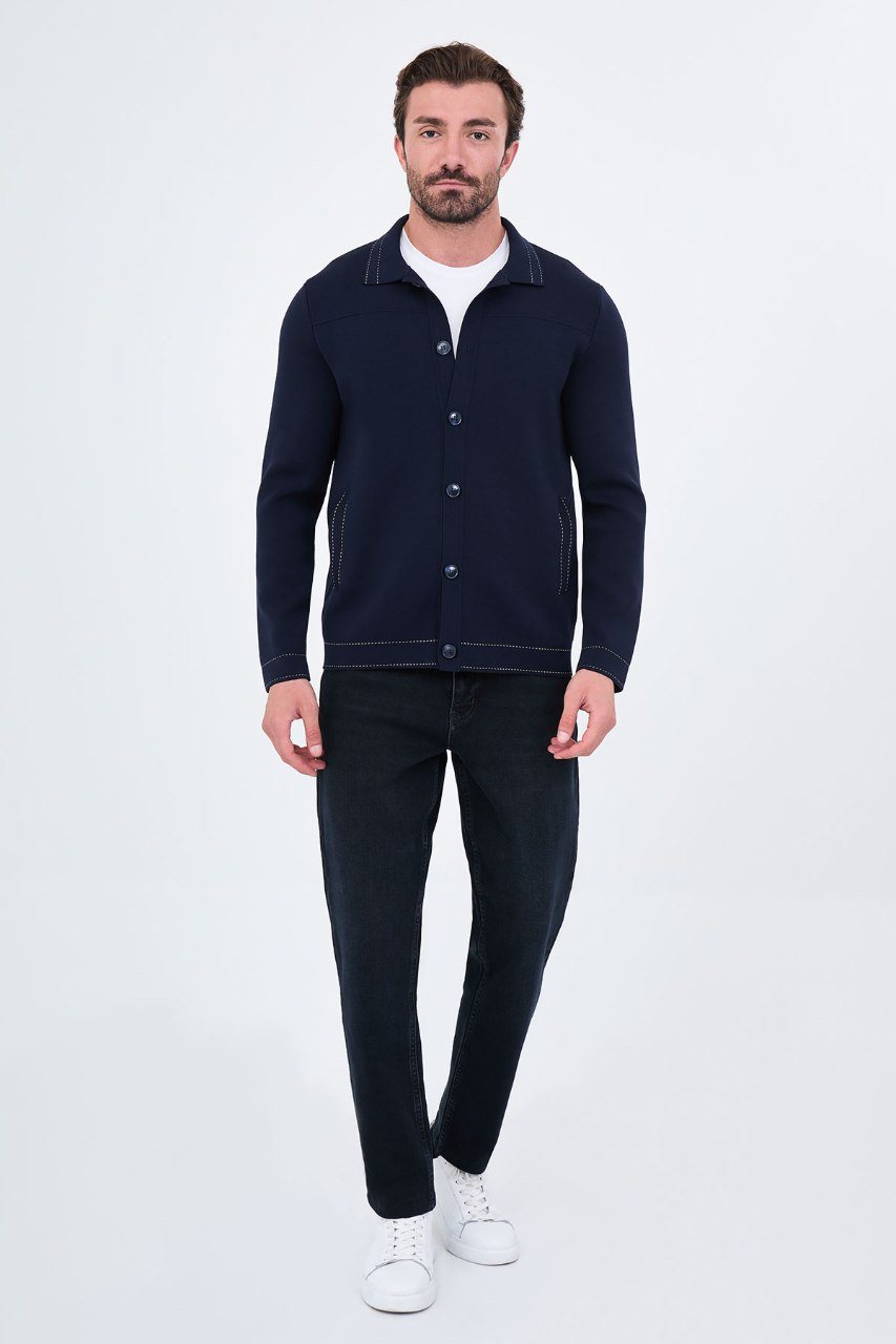Man wearing a navy button-front cardigan with contrast trim, full outfit view