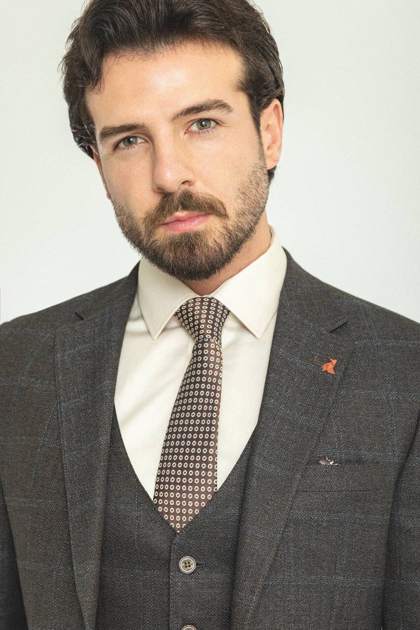 Man in a dark blue patterned 3-piece suit, showcasing elegance and style.