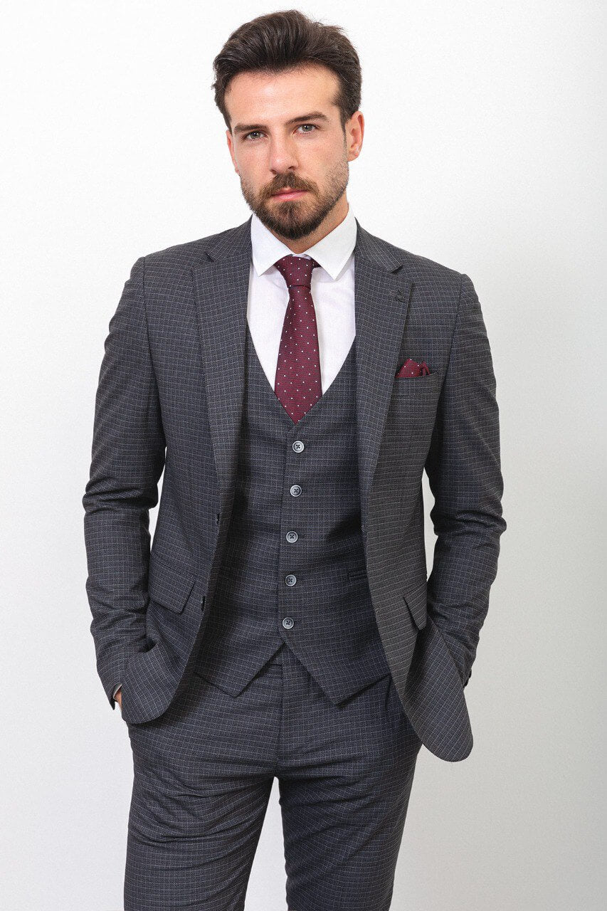 Man wearing a dark gray checkered suit with a burgundy tie and pocket square.