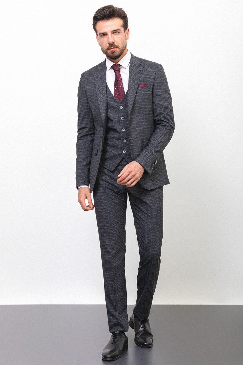 Man wearing a dark gray checkered suit with a burgundy tie and pocket square.