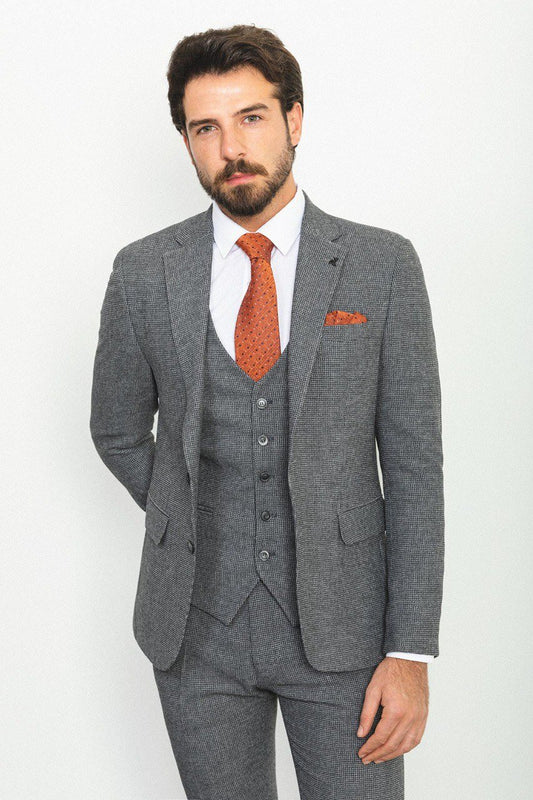 Man wearing a plaid dark gray 3-piece suit with an orange tie and pocket square.