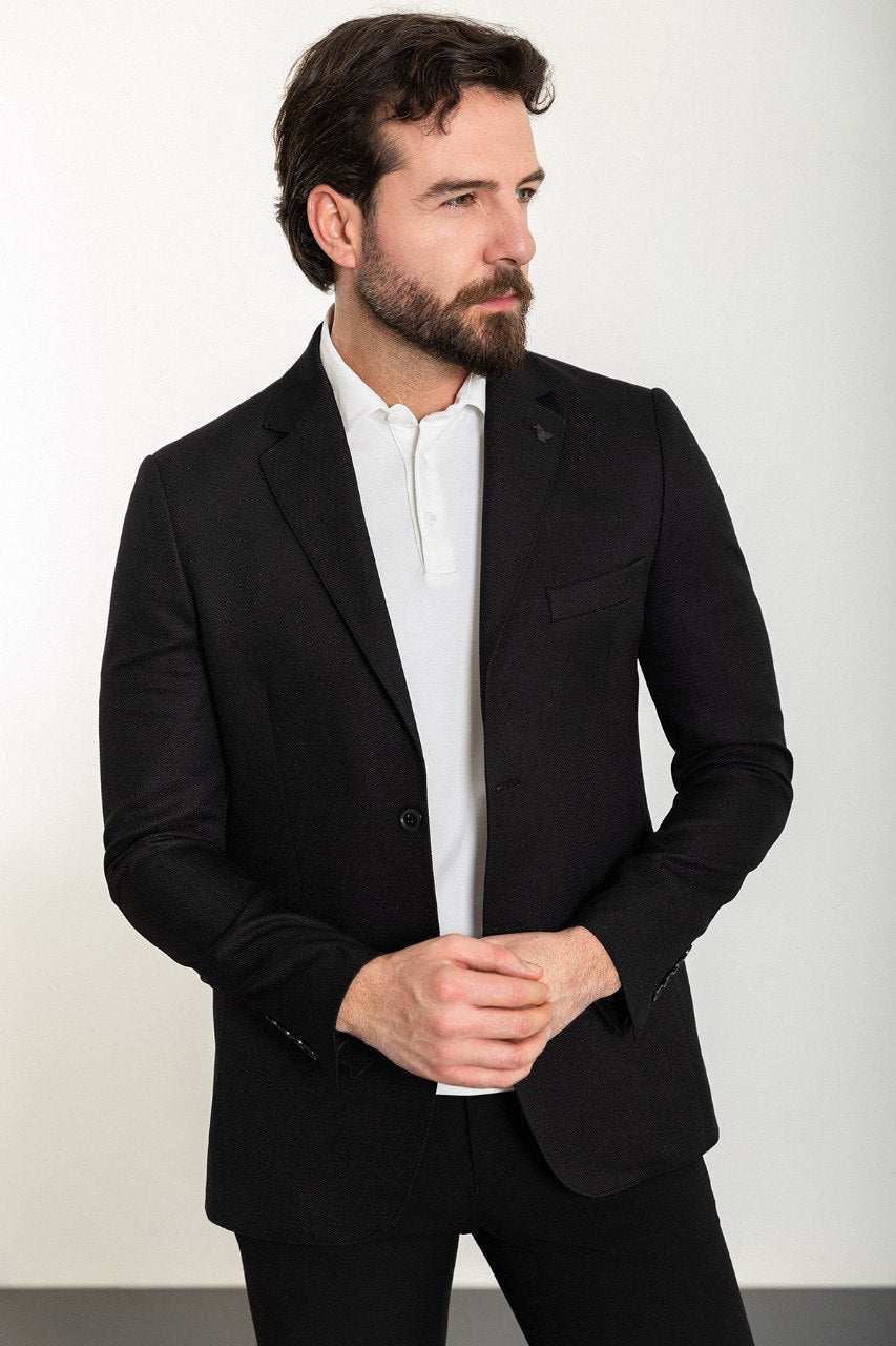 Man wearing a Midnight Elegance Blazer with a sharp pointed collar, flap pockets, and a double-button closure, perfect for formal and evening occasions.