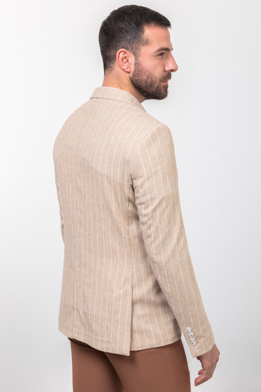 Man wearing a beige pinstripe blazer paired with brown trousers.