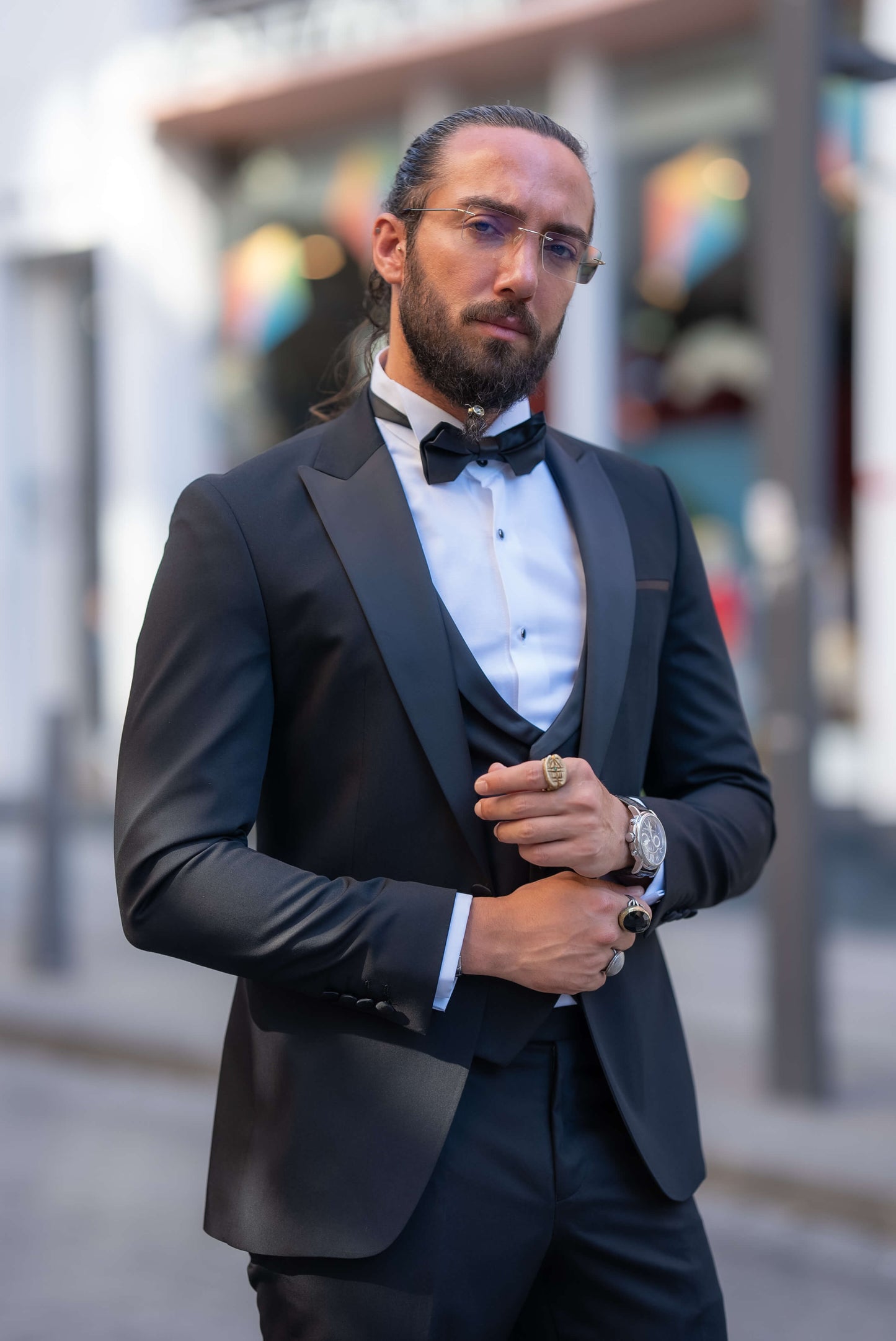 Elegant man wearing a black tuxedo with a bow tie, perfect for fall weddings and formal events.