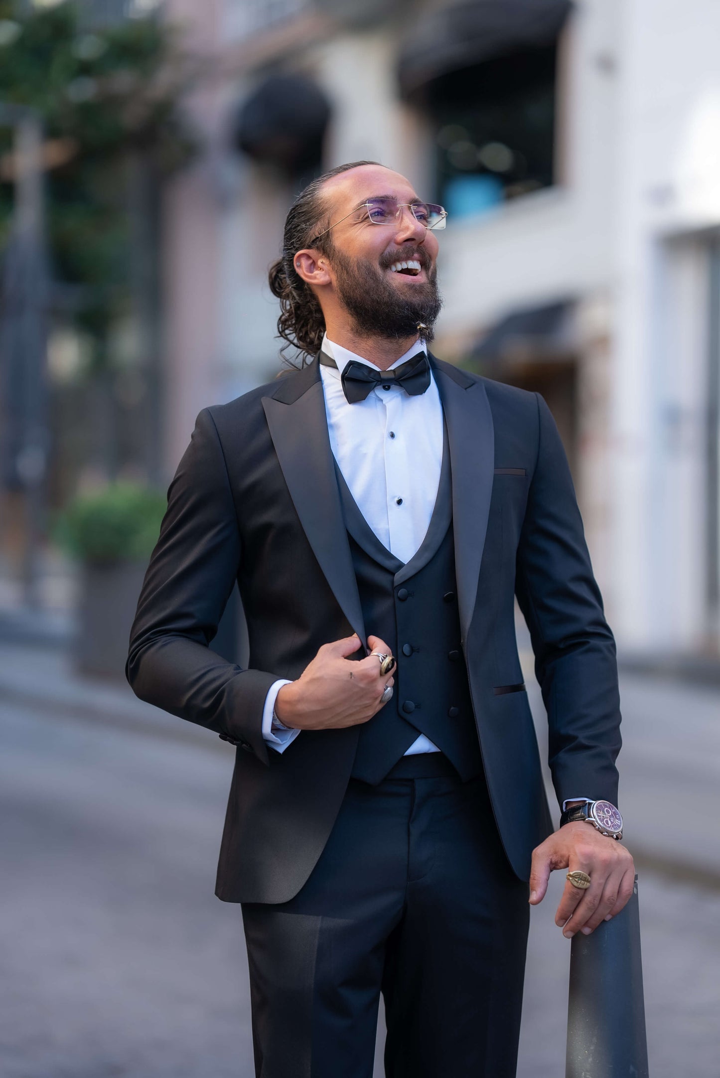 Elegant man wearing a black tuxedo with a bow tie, perfect for fall weddings and formal events.