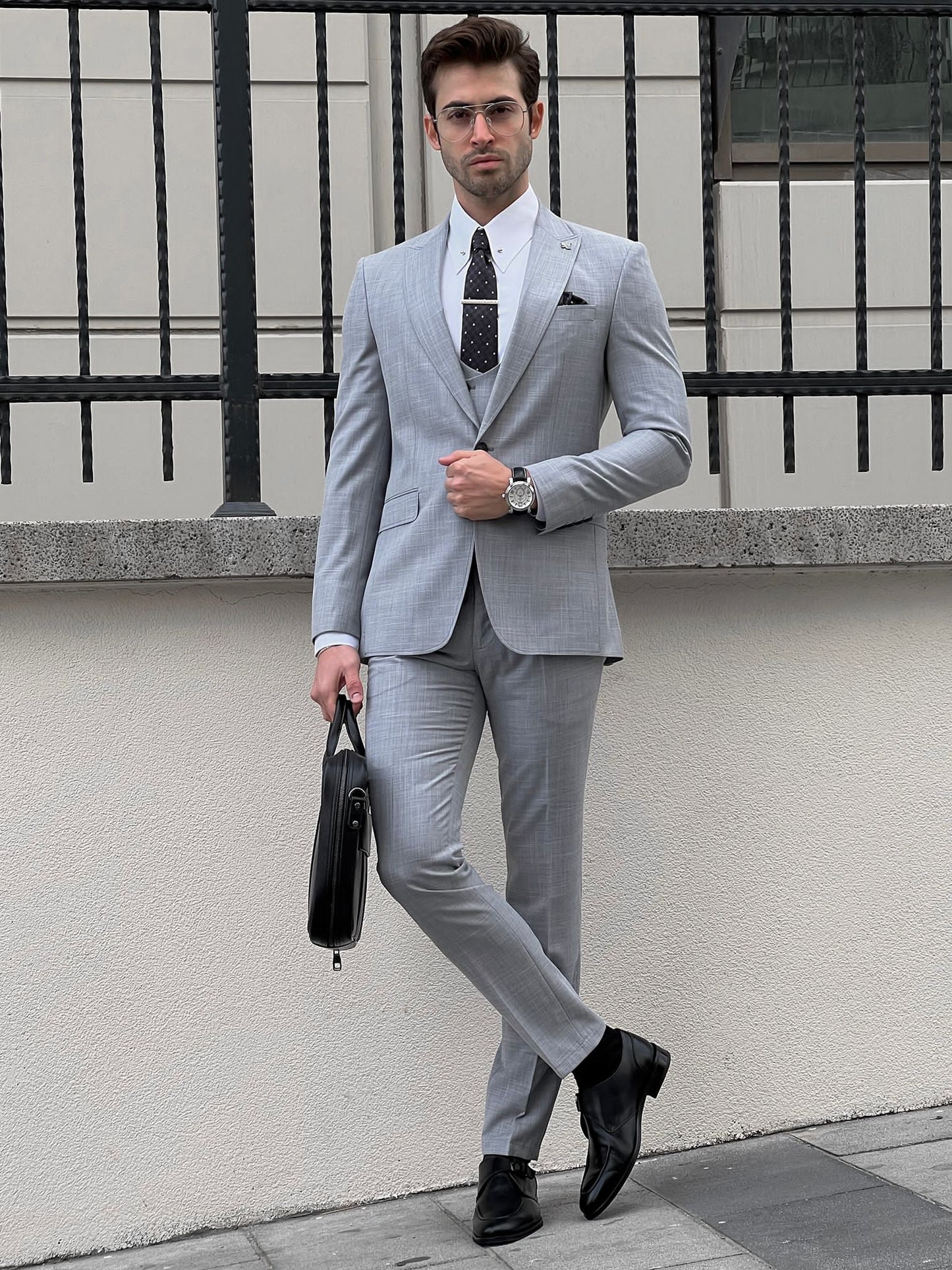 Confident man wearing a fitted gray suit.