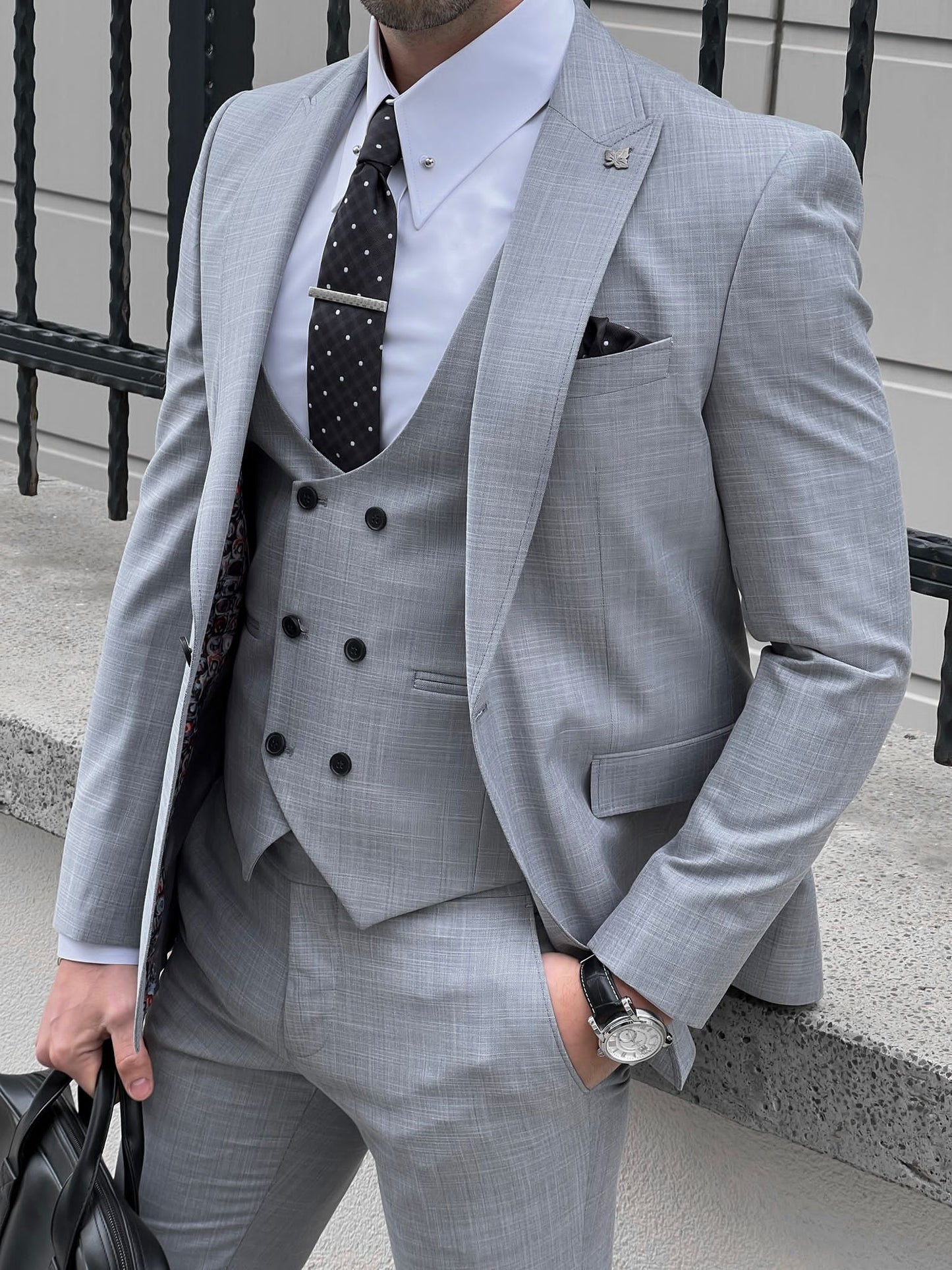 Confident man wearing a fitted gray suit.