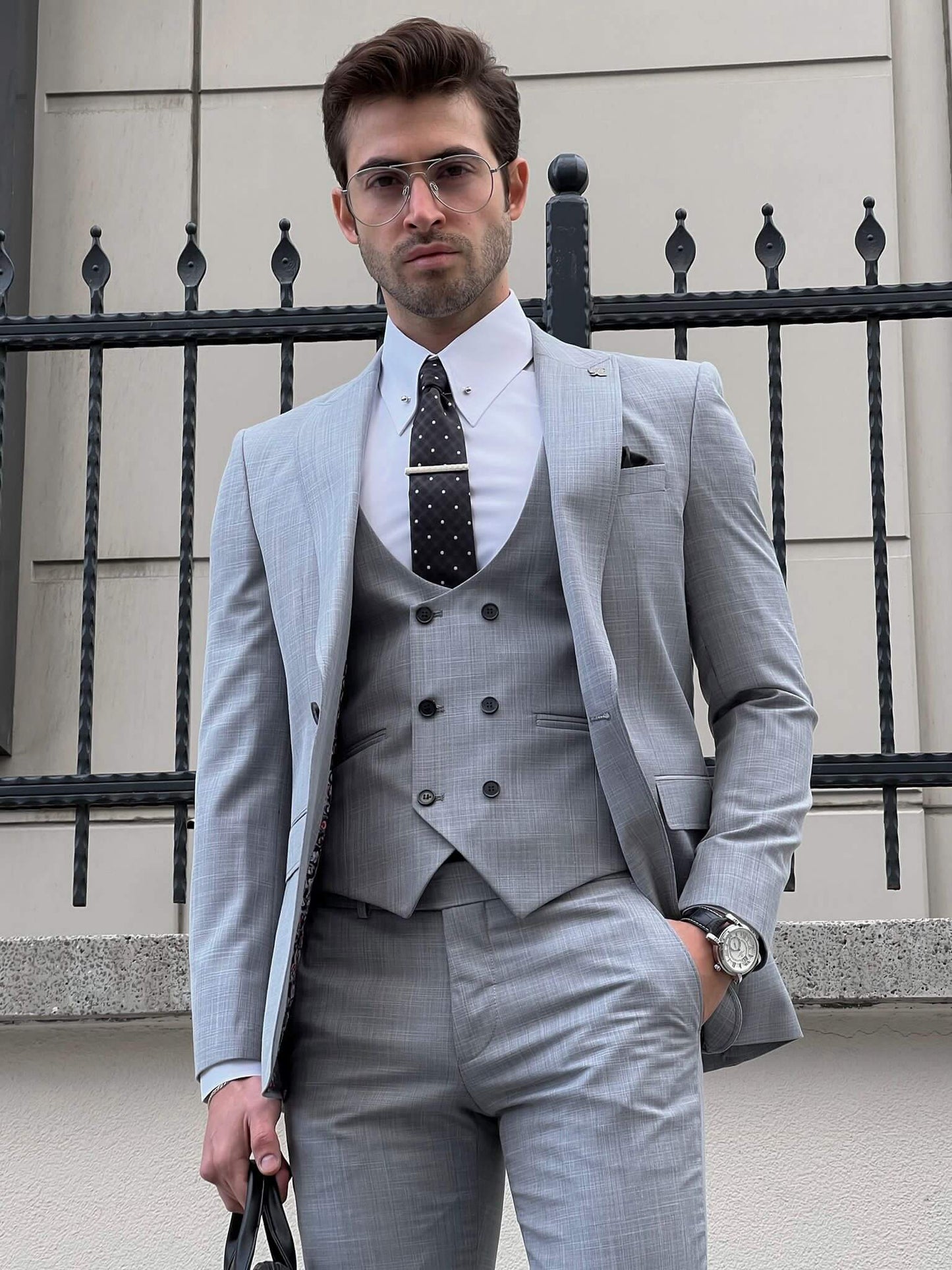 Confident man wearing a fitted gray suit.