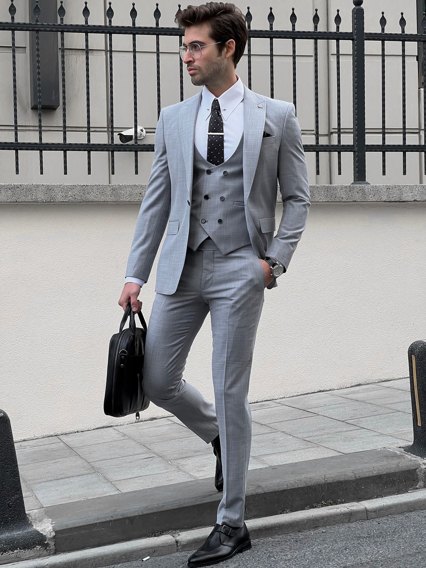 Confident man wearing a fitted gray suit.