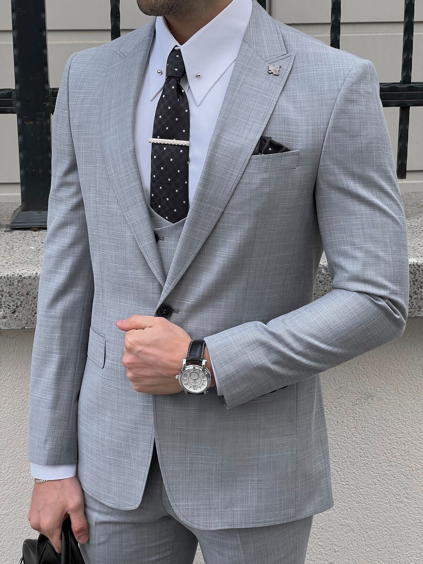 Confident man wearing a fitted gray suit.