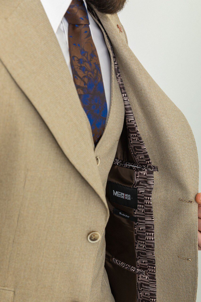 Man in a plaid beige 3-piece suit with a blue tie and pocket square.