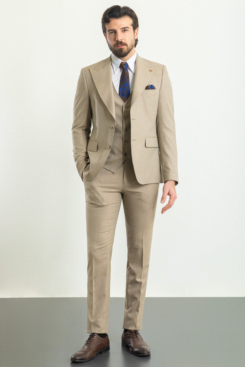 Man in a plaid beige 3-piece suit with a blue tie and pocket square.