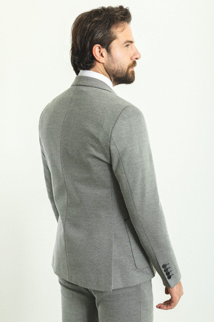 Man wearing a stylish gray 3-piece suit with a black tie and black shoes.