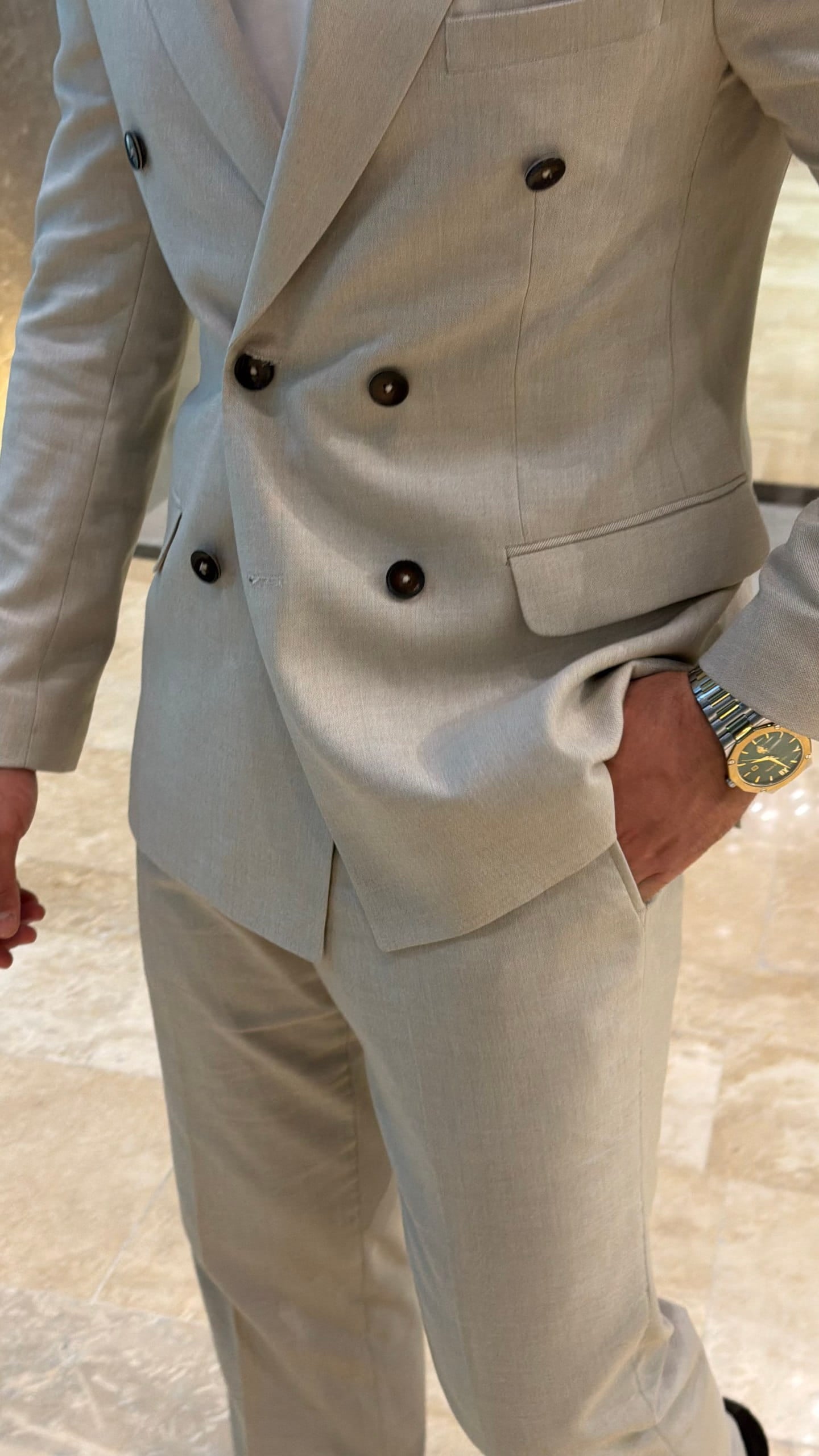 Men's beige double-breasted suit shown from an angled view