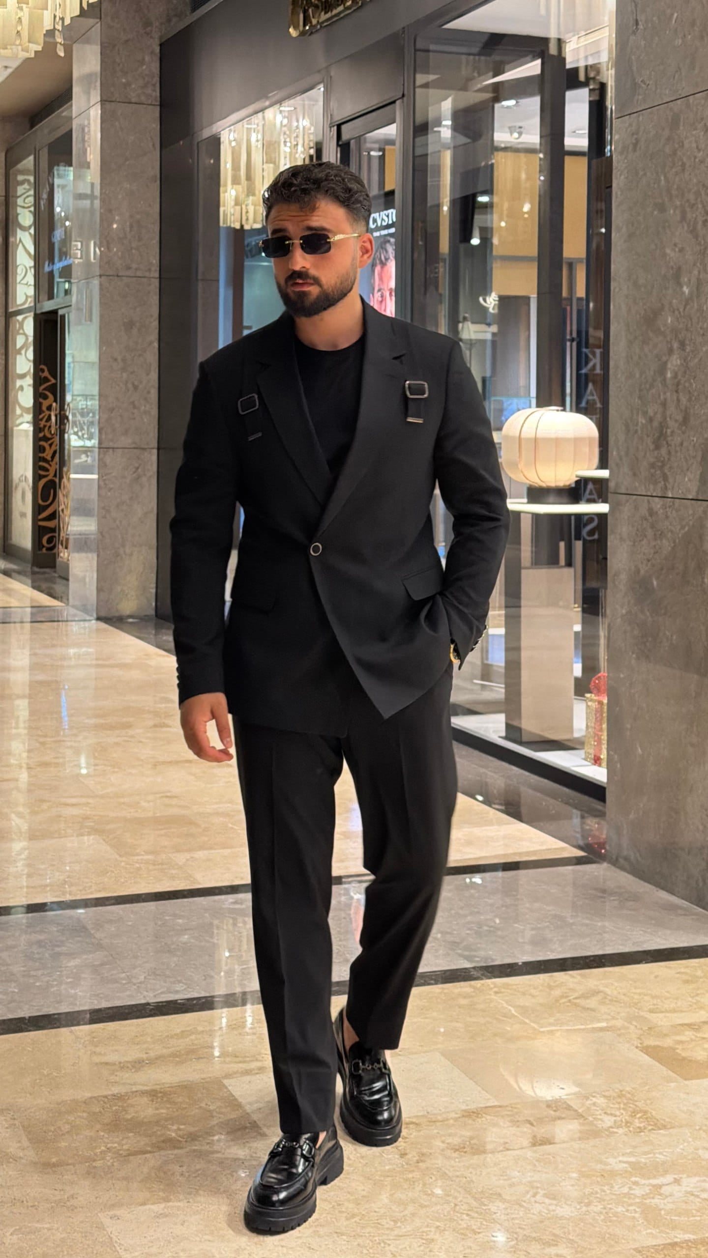 Black formal suit showing notch lapel and front buckle strap