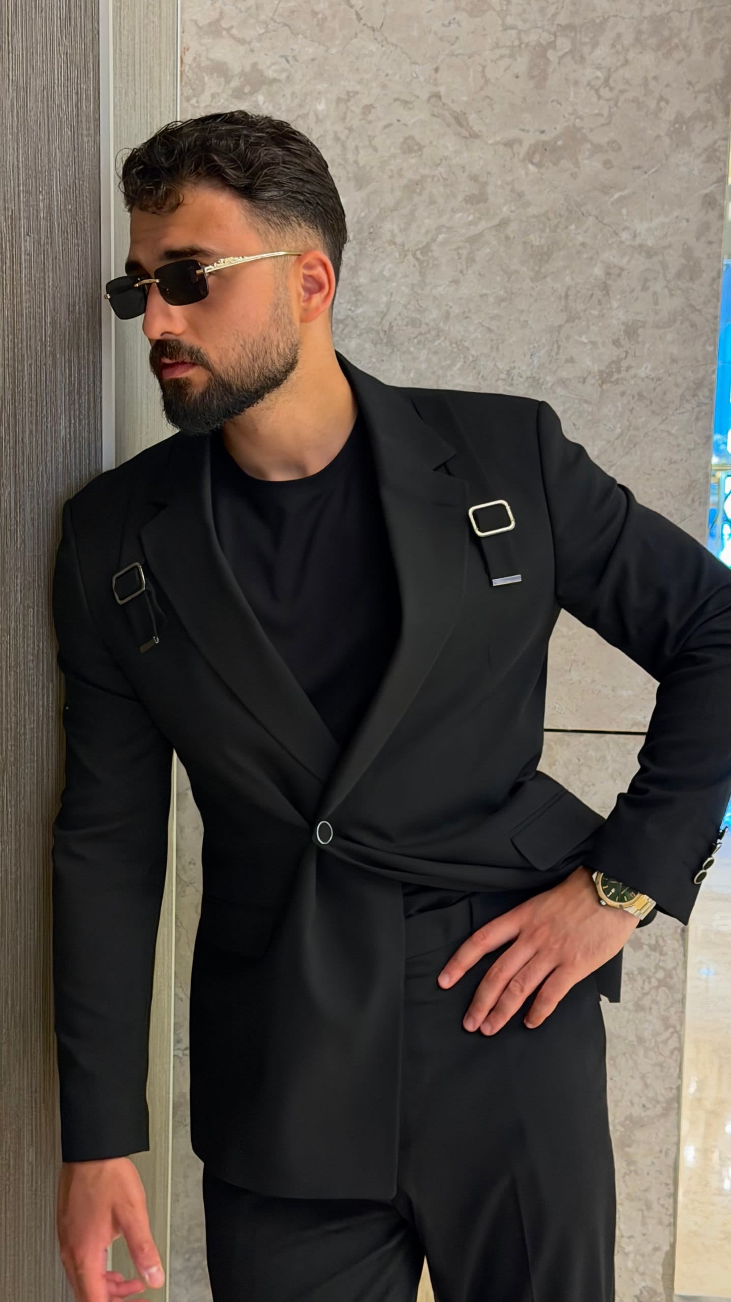 Black two-piece suit with single-button jacket and metal cuffs