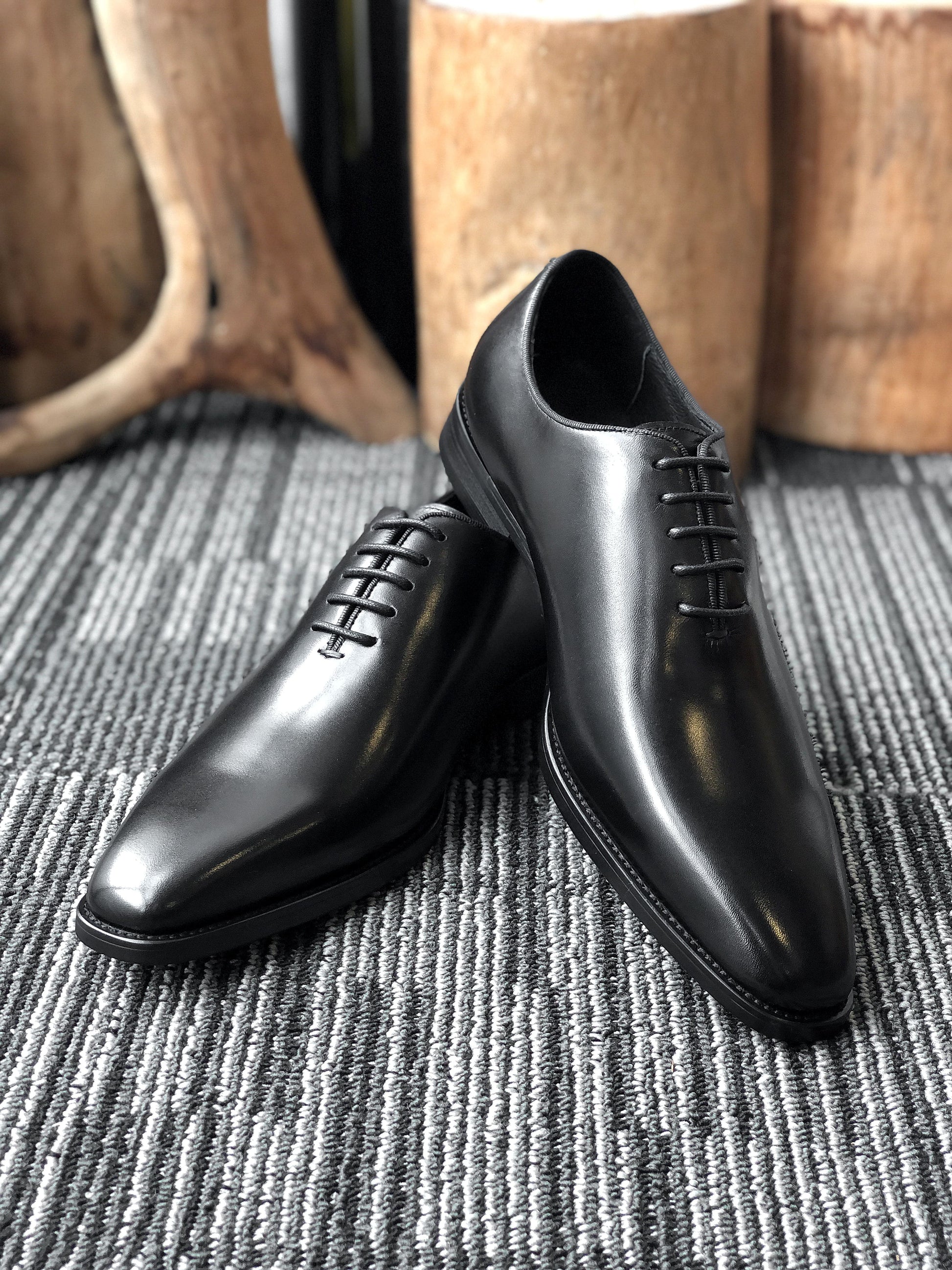 A pair of sleek Black Leather Oxford Shoes, featuring a polished finish, ideal for formal wear and business attire.