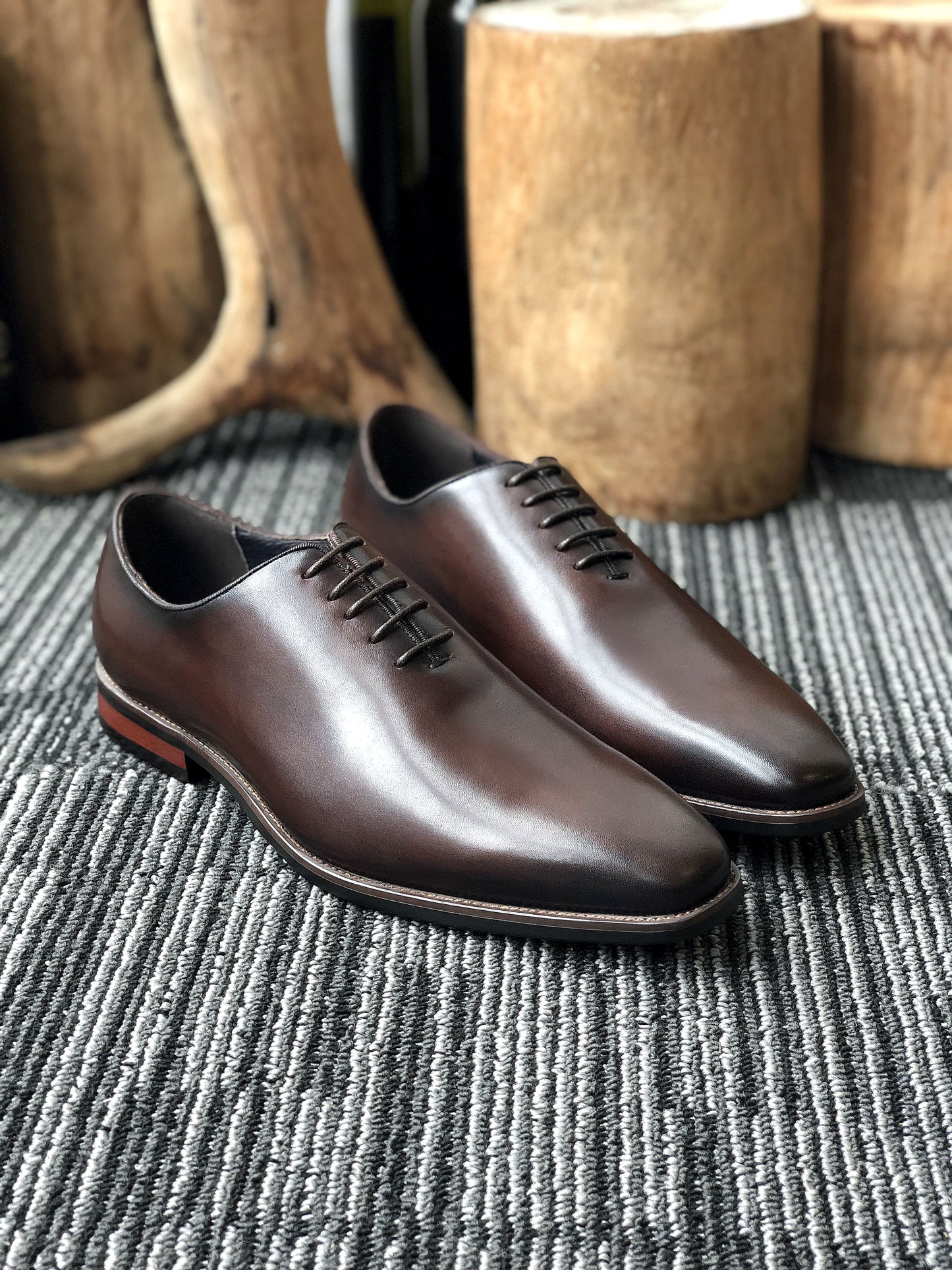 A pair of handcrafted Brown Leather Oxford Shoes, featuring a polished finish and sleek design, ideal for formal wear and business attire.