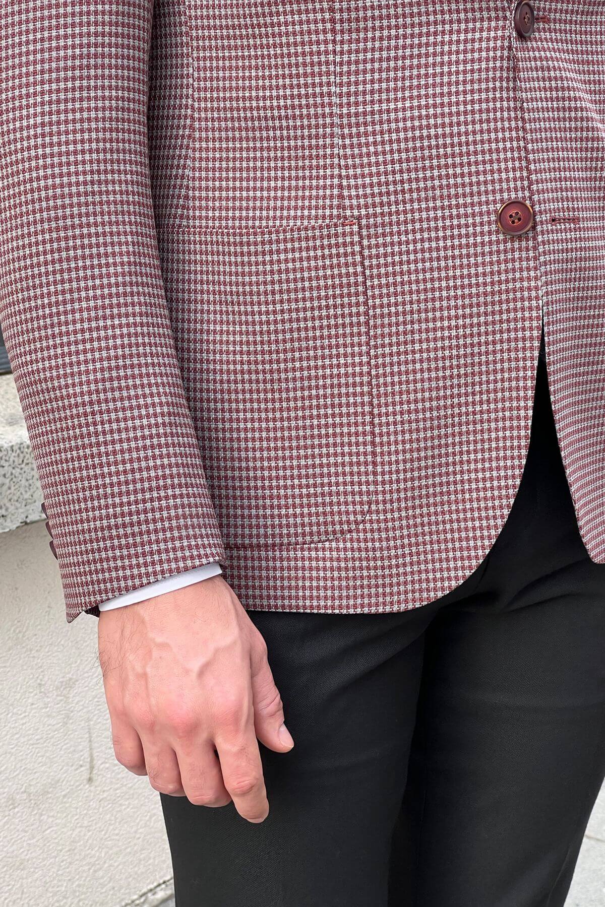Close-up of a person wearing a red and white checkered shirt with black pants.
