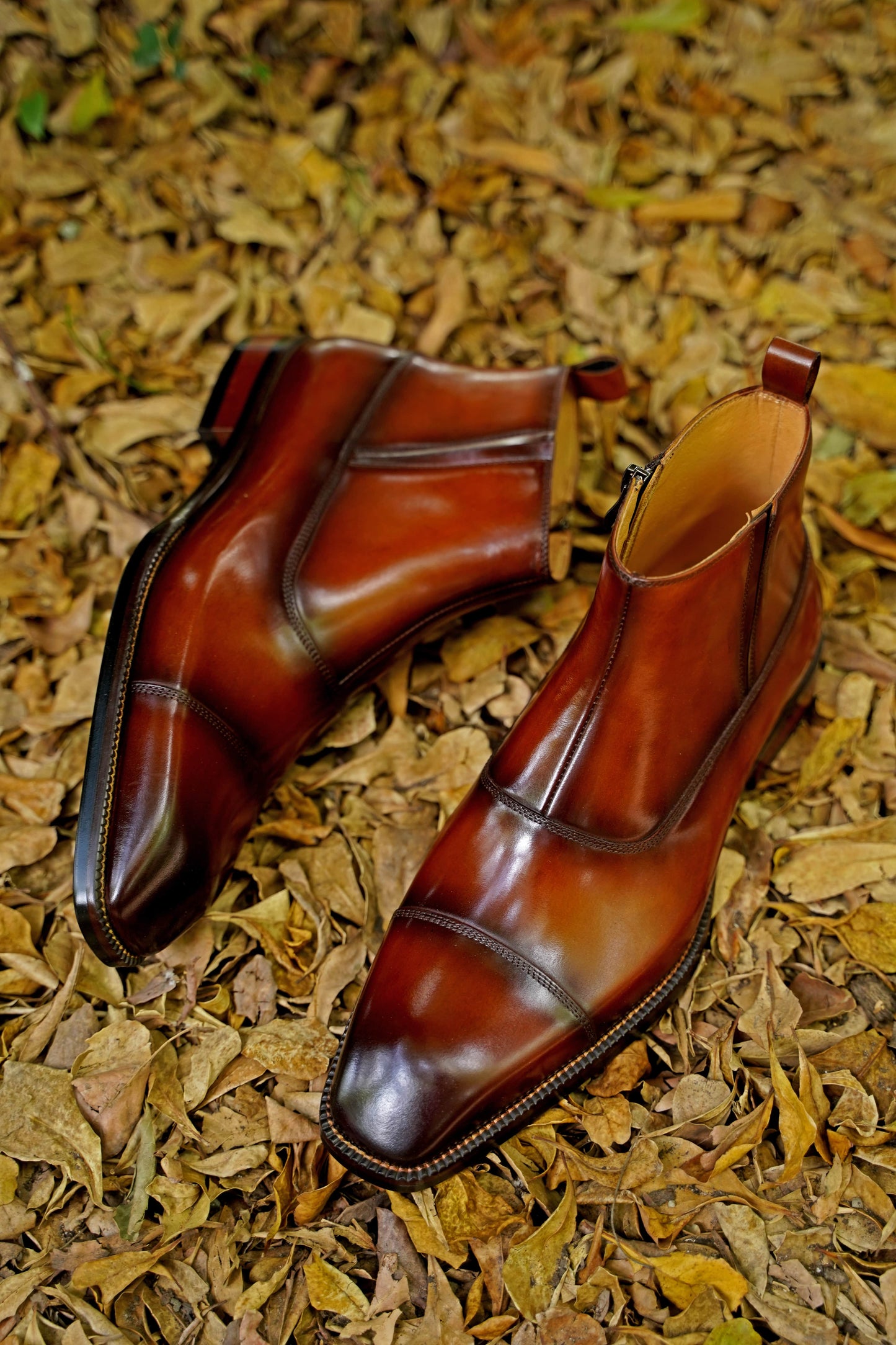 A pair of handcrafted Chestnut Leather Boots with a polished finish, featuring a sleek and elegant design, perfect for formal and business wear.