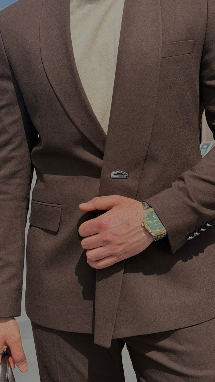 Brown suit jacket worn by a person, with a focus on the lapel and pocket area.