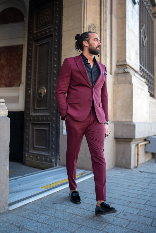 Man wearing a burgundy Italian cut tuxedo suit, paired with a black shirt, perfect for men's fall fashion and formal events.