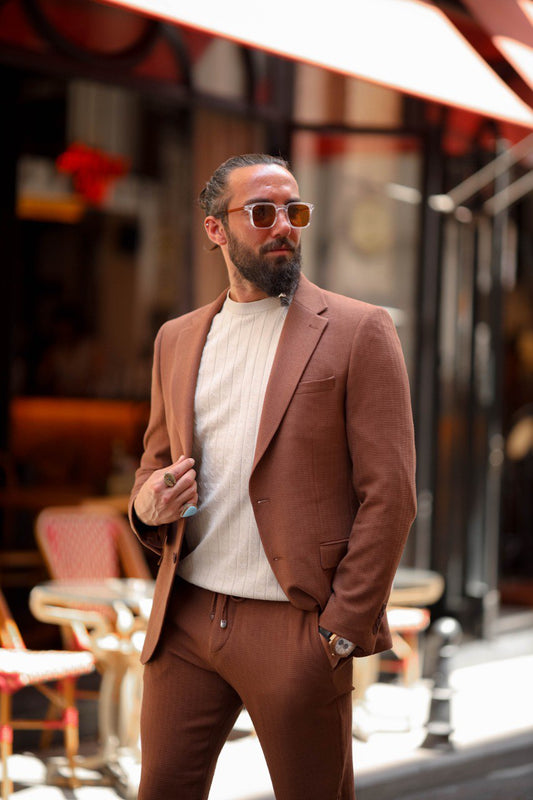 Men’s light brown slim fit summer suit styled with a knit top for smart casual wear.