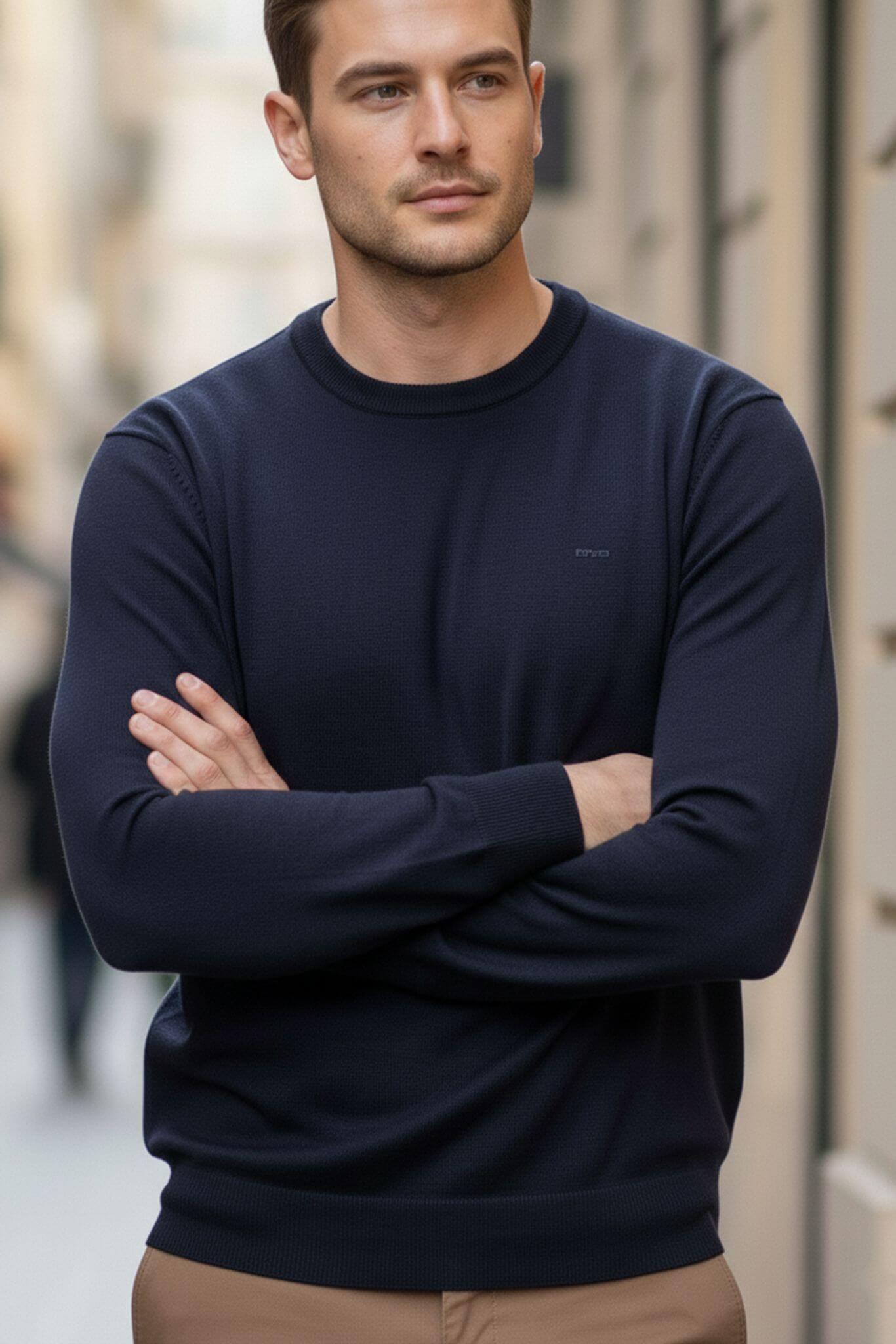 Man wearing a navy sweater with a blurred background