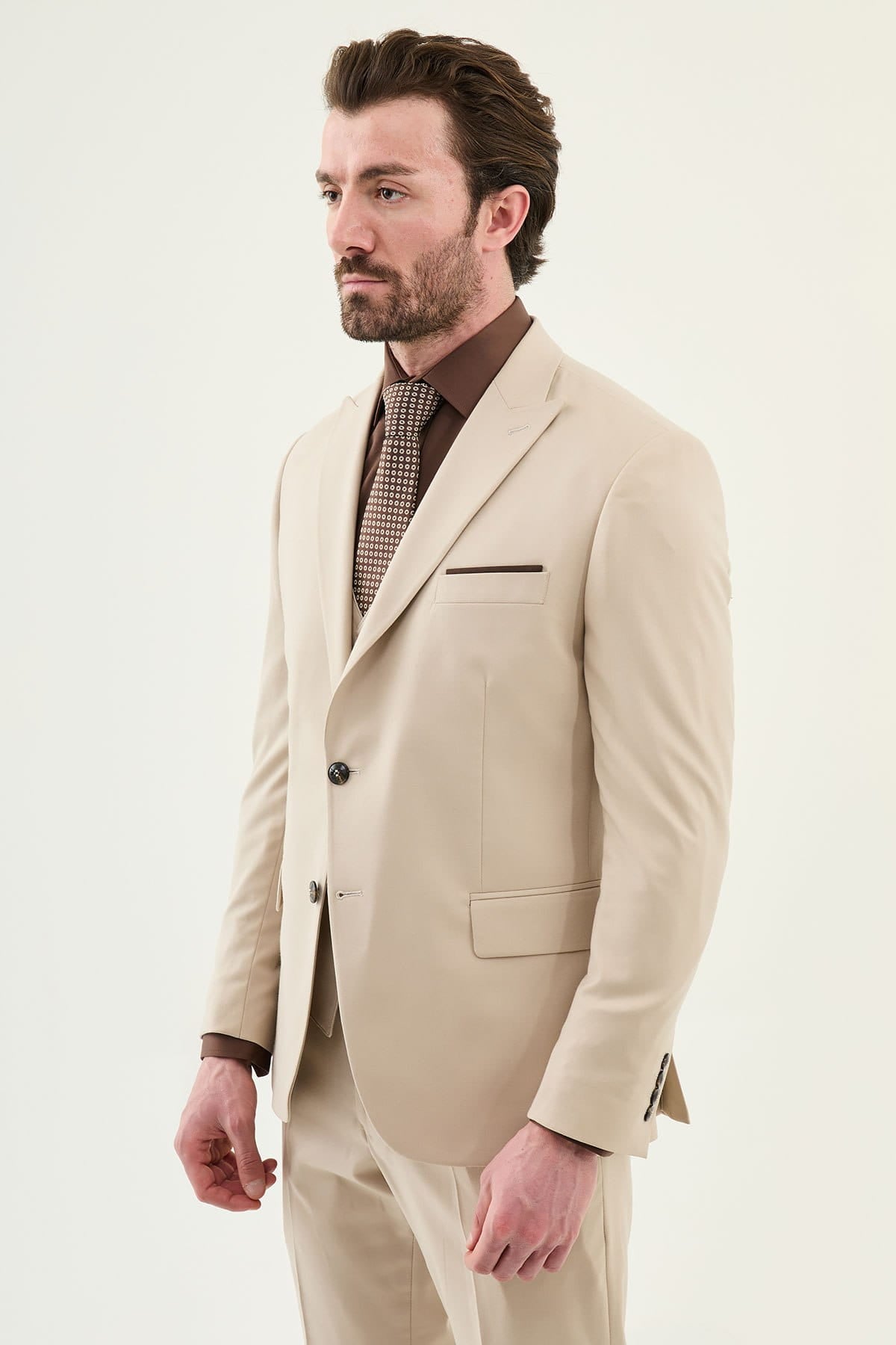 Man wearing a beige suit with a white background