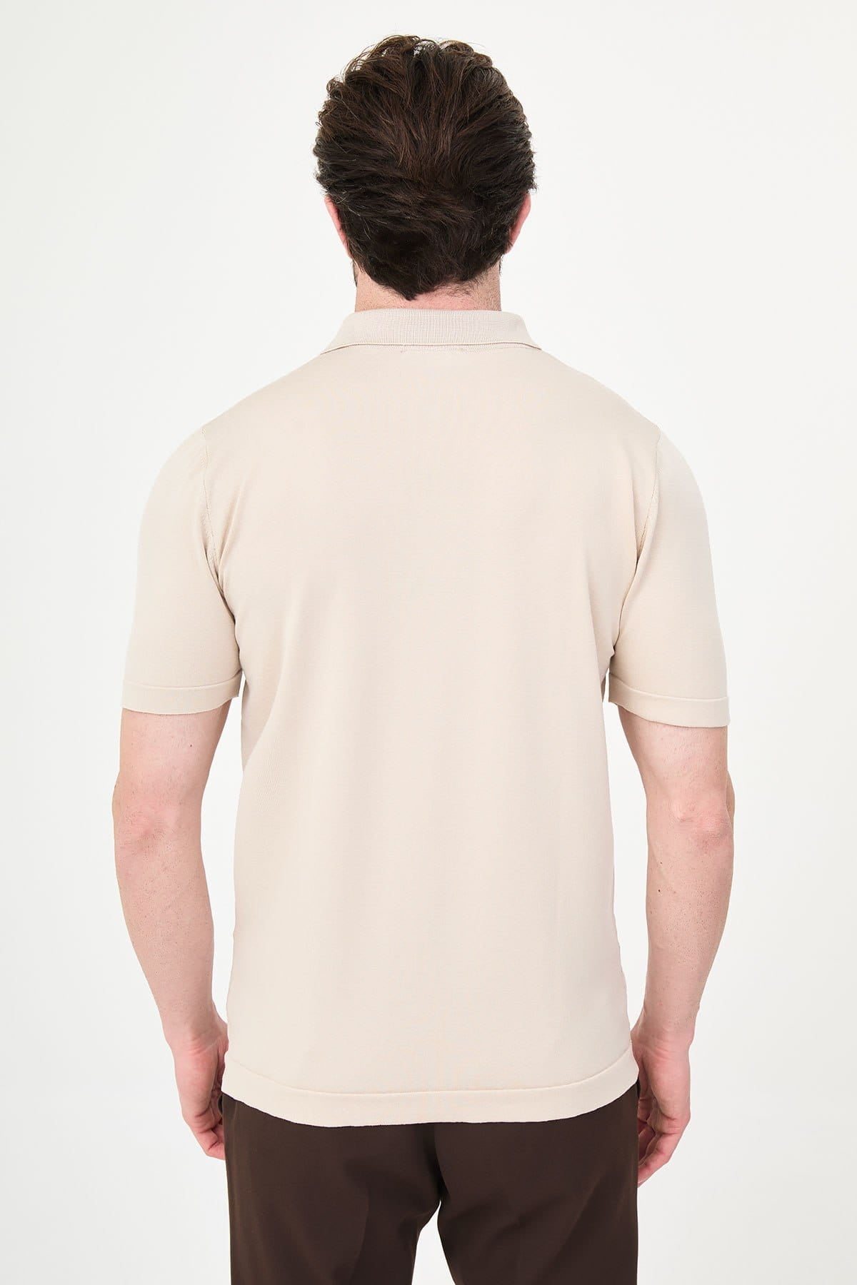 Man wearing a beige polo shirt on a white background