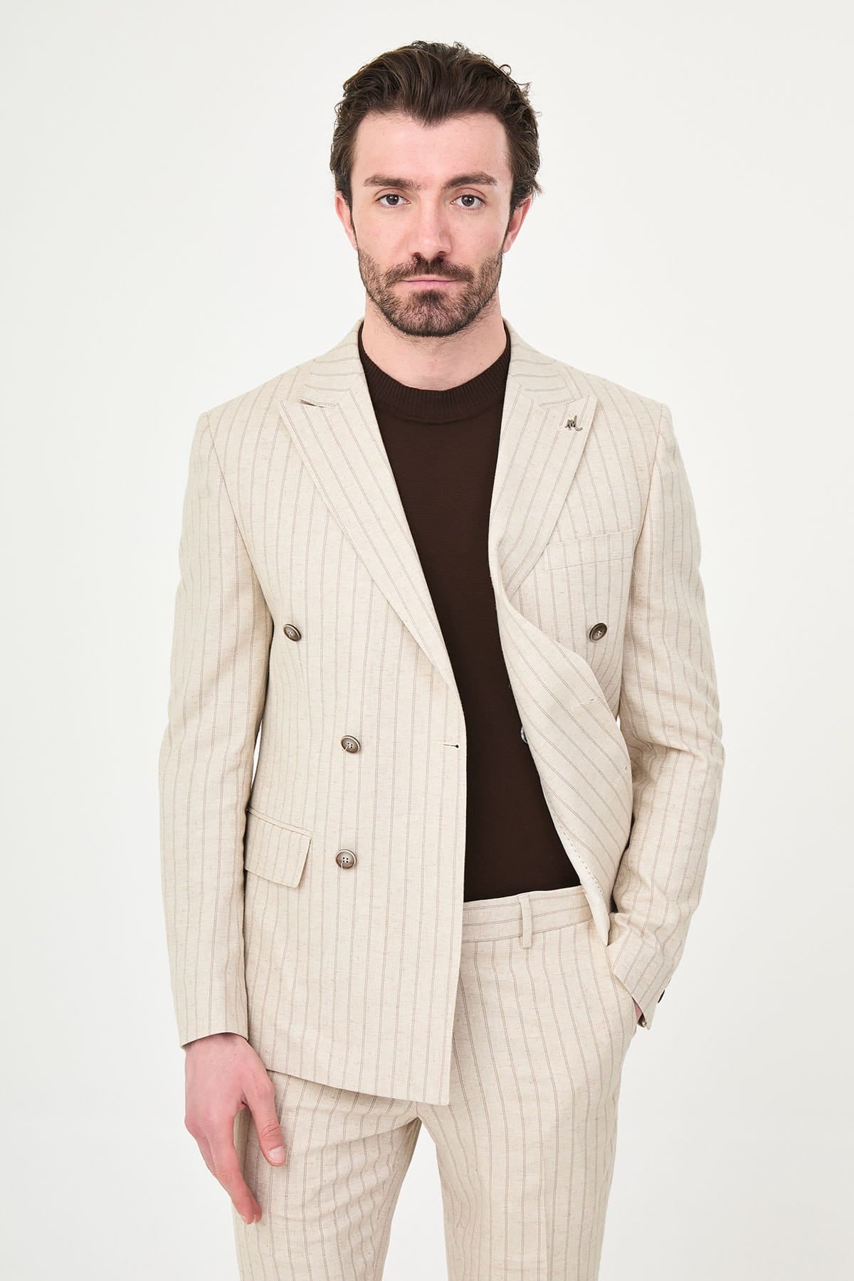 Man wearing a beige pinstripe suit with a white background