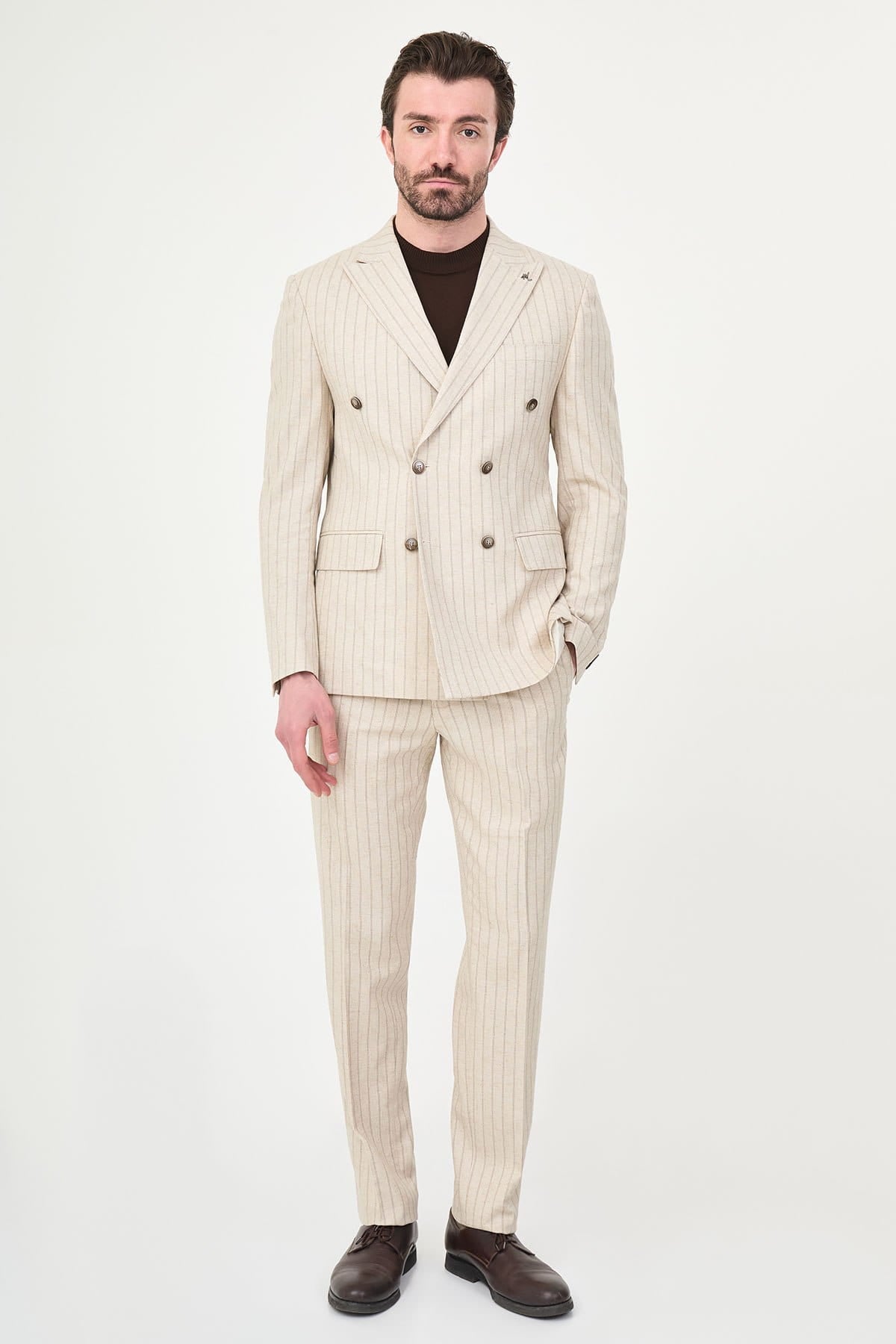 Man wearing a beige pinstripe suit on a white background