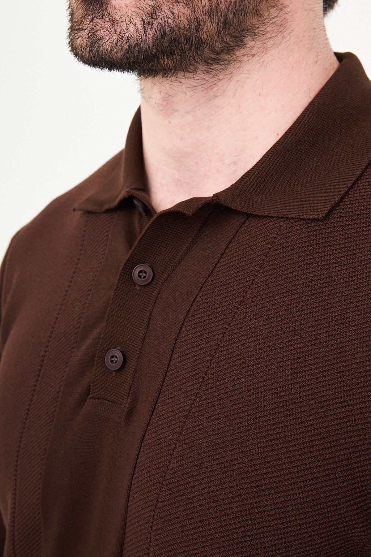 Brown polo shirt worn by a person on a white background