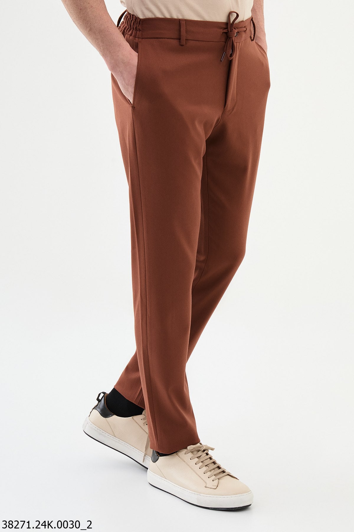 Brown pants worn by a person on a white background