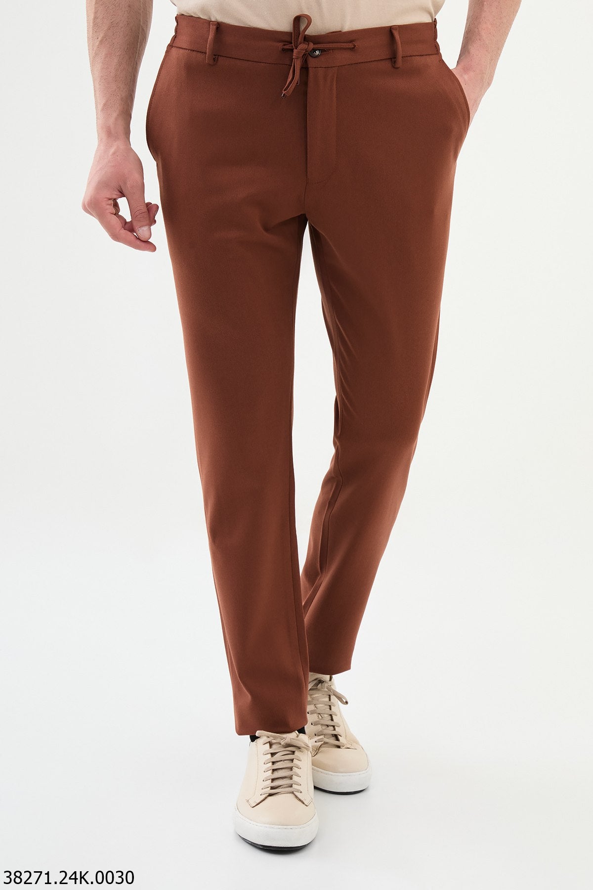 Brown pants worn by a person on a white background