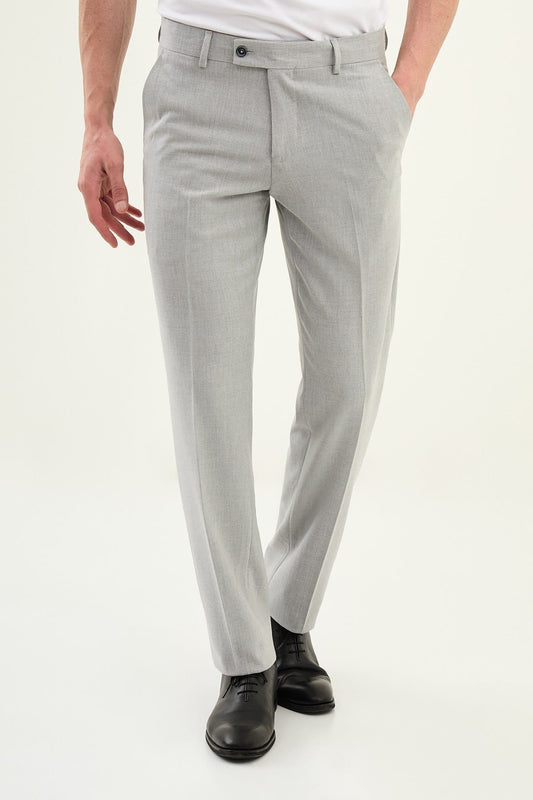 Person wearing light gray pants and black shoes on a white background