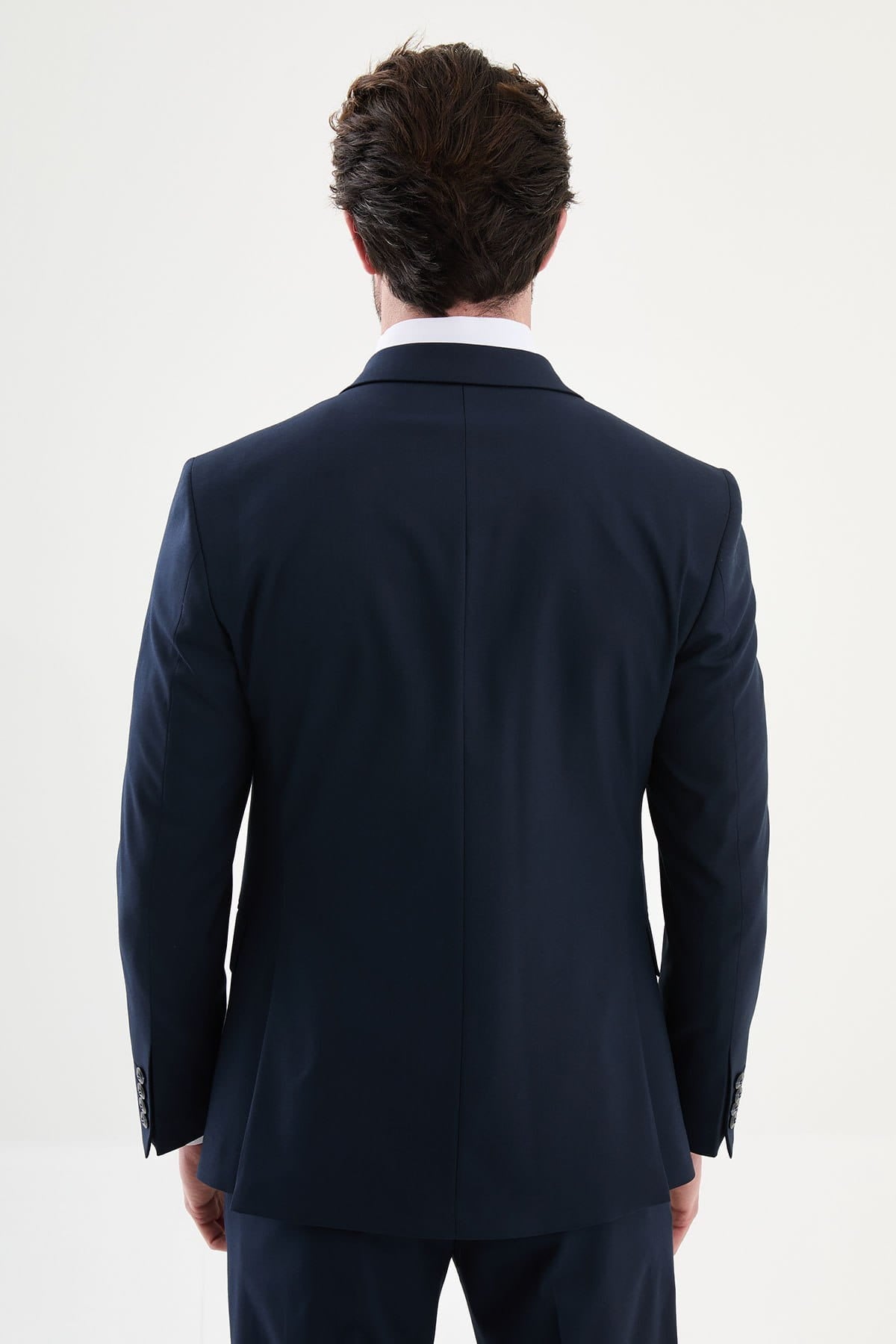Man wearing a navy suit jacket on a white background