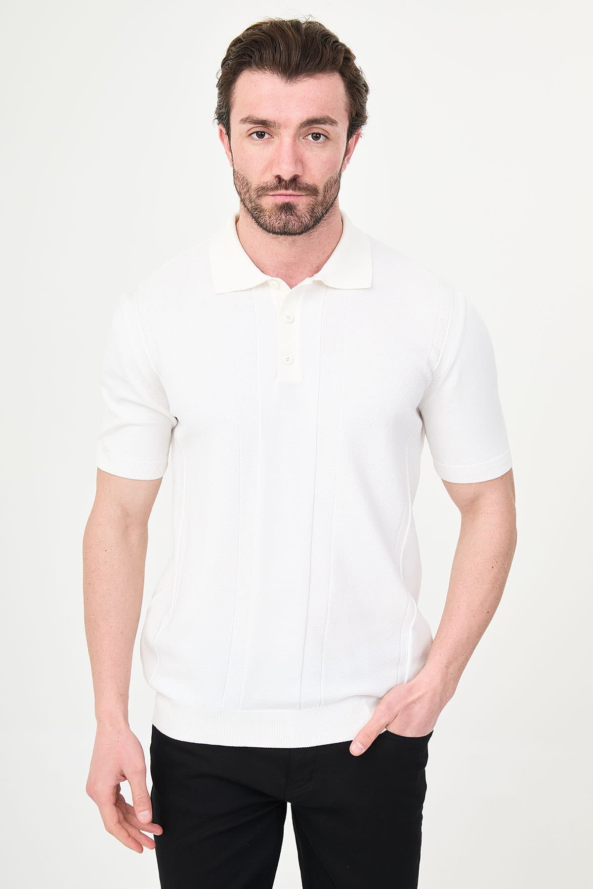 Man wearing a white polo shirt and black pants on a white background