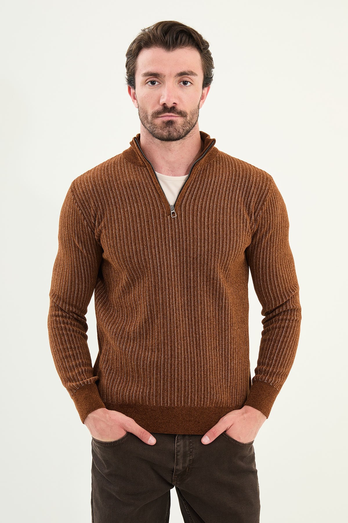 Man wearing a brown ribbed sweater against a white background