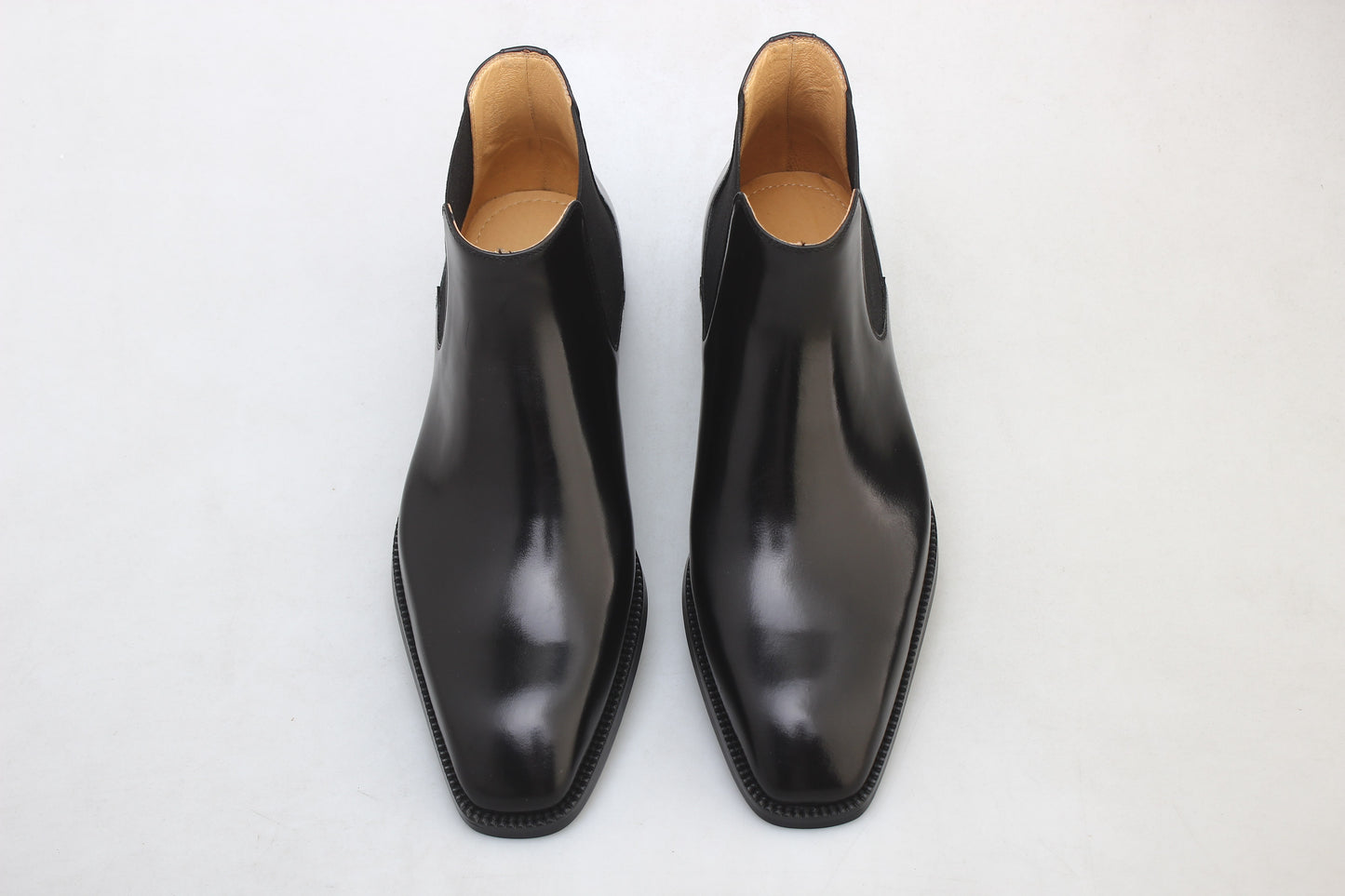 A pair of Noir Chelsea Boots featuring sleek, polished black leather, perfect for formal and business occasions.