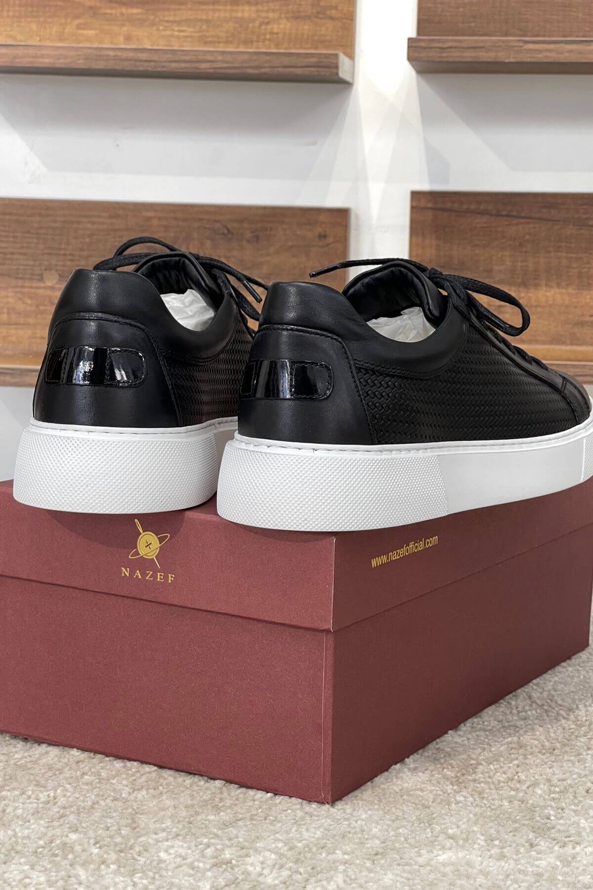 Black sneakers with white soles on a red box, brand 'Nazeer' visible