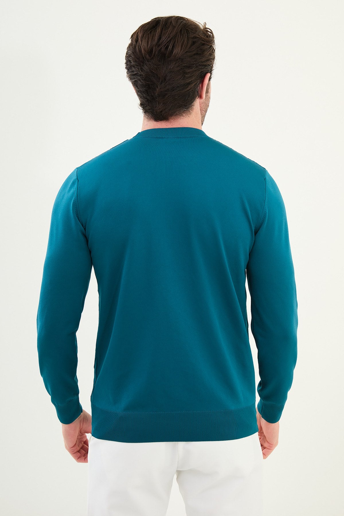 Man wearing a teal sweater on a white background