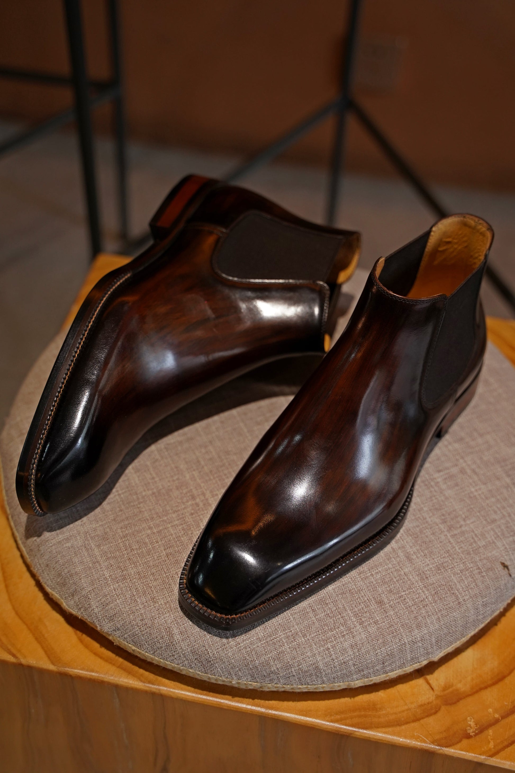 A pair of polished brown leather Chelsea boots, featuring a sleek design, perfect for formal and business wear.