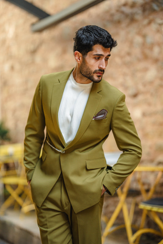 Man wearing a green suit with a white shirt in an outdoor setting