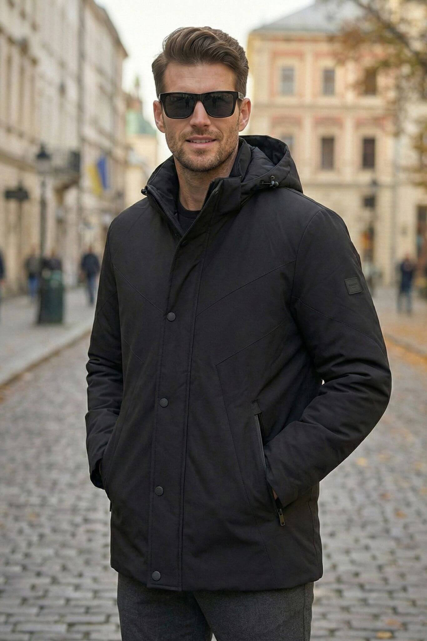 Man wearing a black coat and sunglasses on a city street
