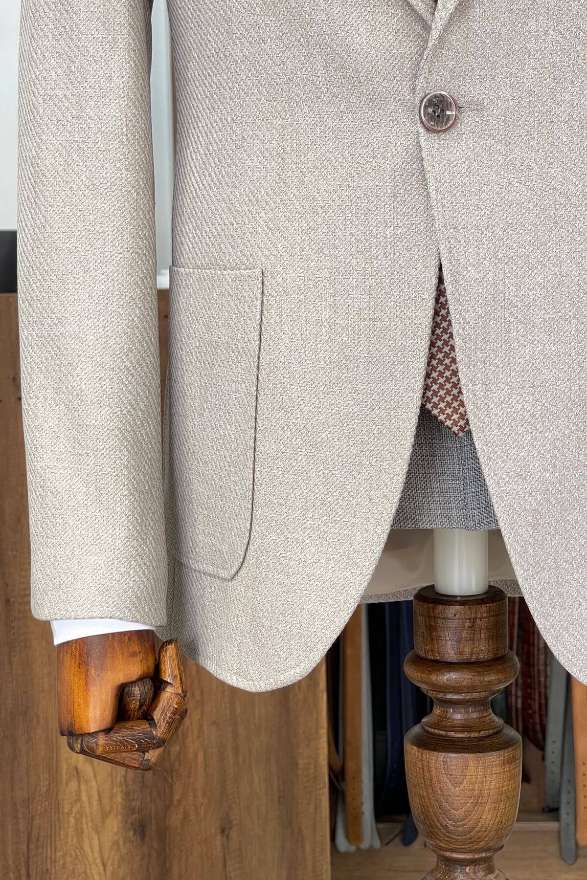 Close-up of a beige textured coat with wooden furniture in the background