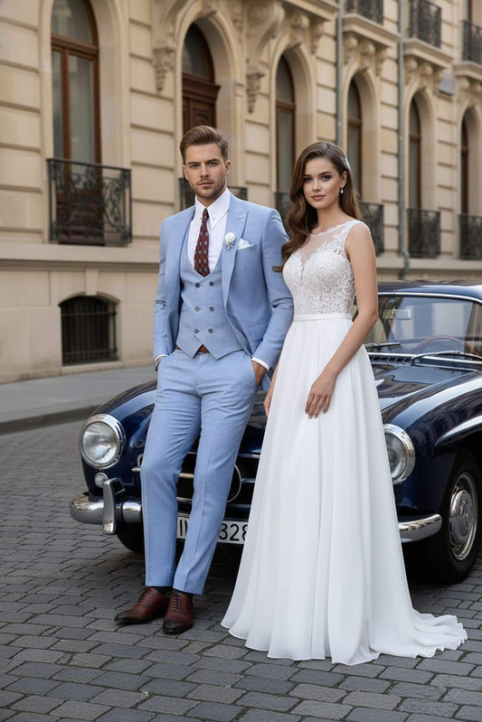 Man in a light blue suit and woman in a white dress standing next to a vintage car on a city street.