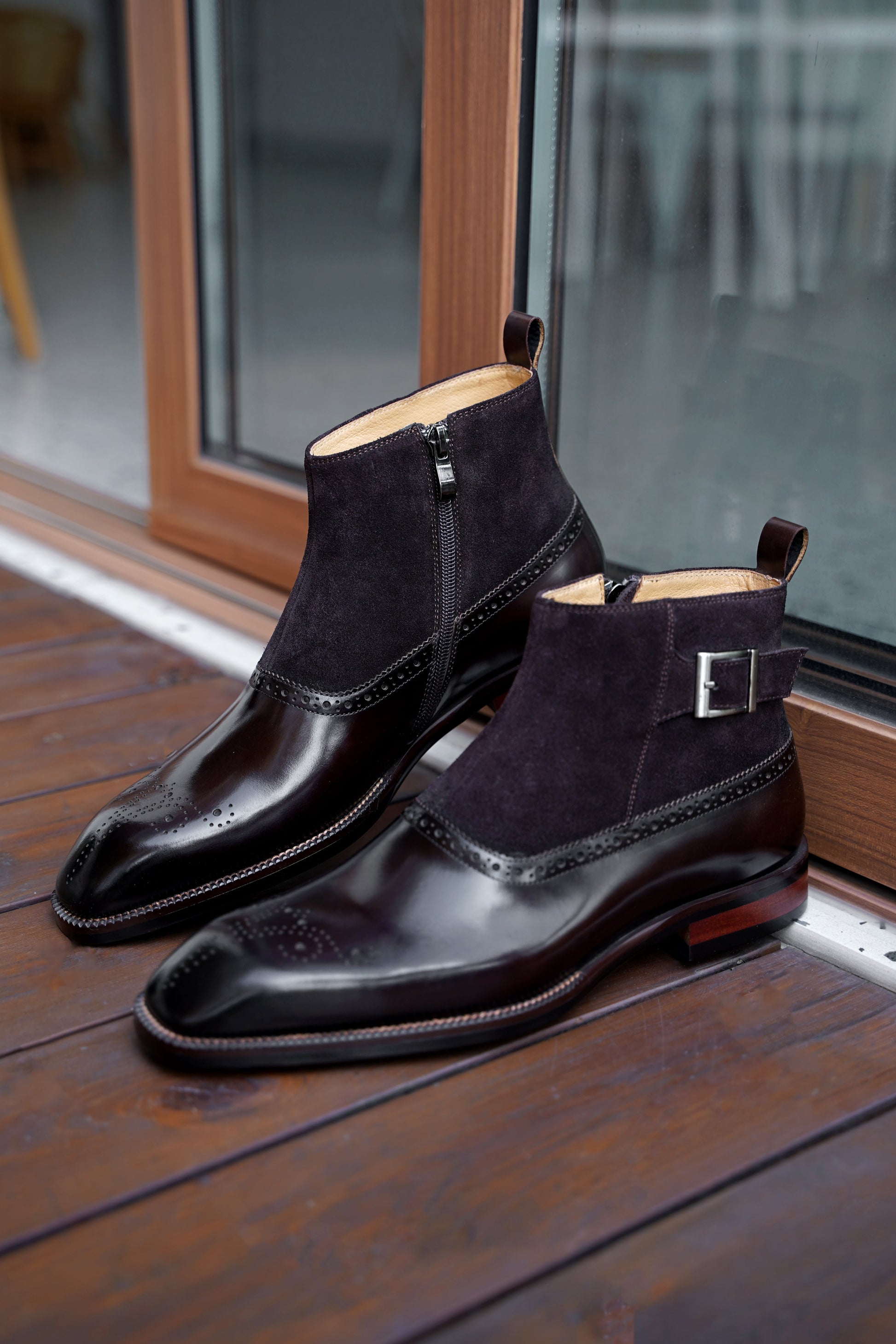 A pair of Men’s Brogue Boots with a combination of suede and polished leather, featuring a zipper and buckle design, perfect for formal and business attire.